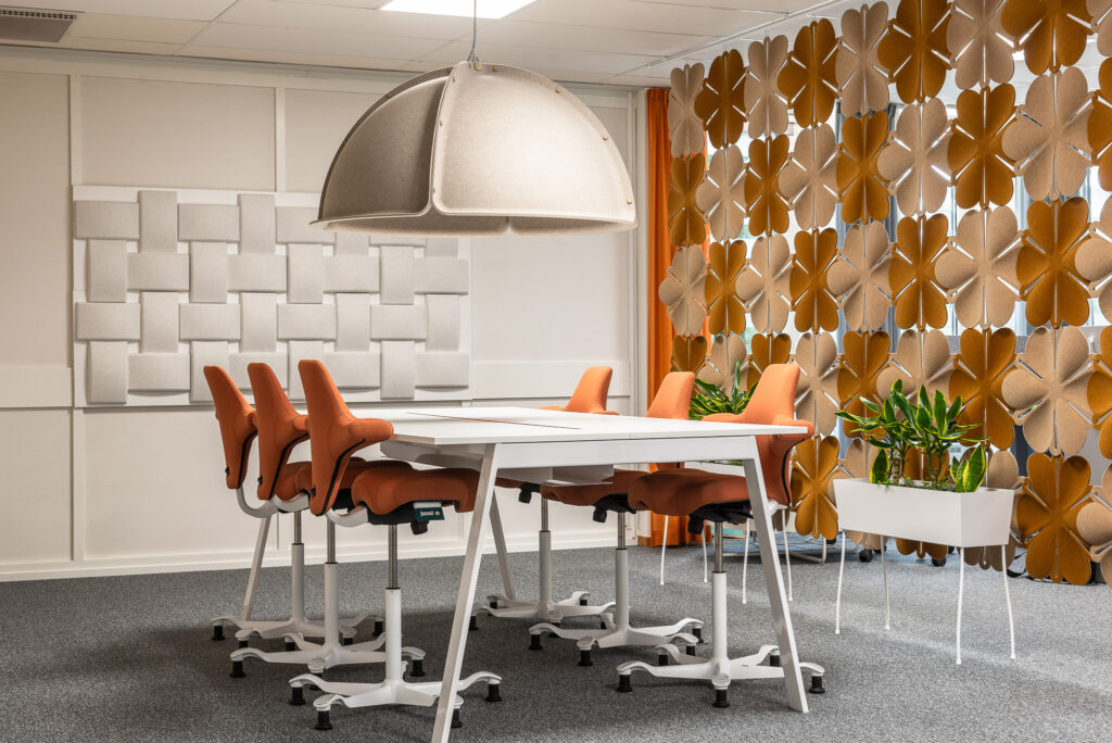 Airflake acoustic hanging screen behind conference table and chairs in an office