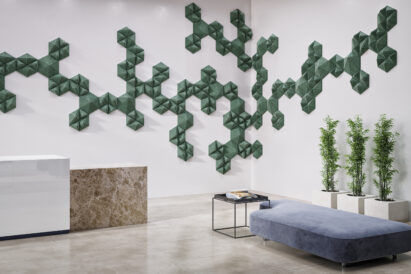 formations of textured dark green geometric shaped acoustic tiles on lobby wall