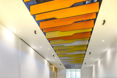 detail of orange yellow and white baffles above office reception area