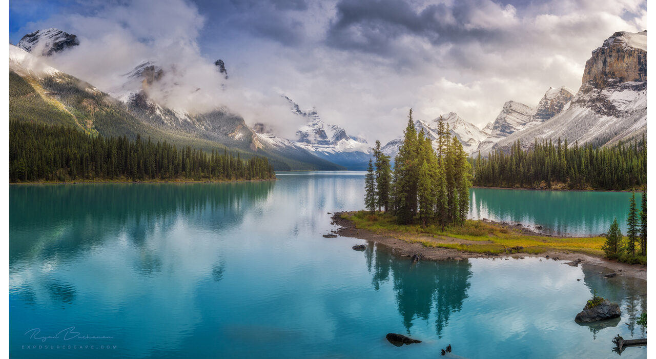 calm blue lake with snow-capped mountains behind