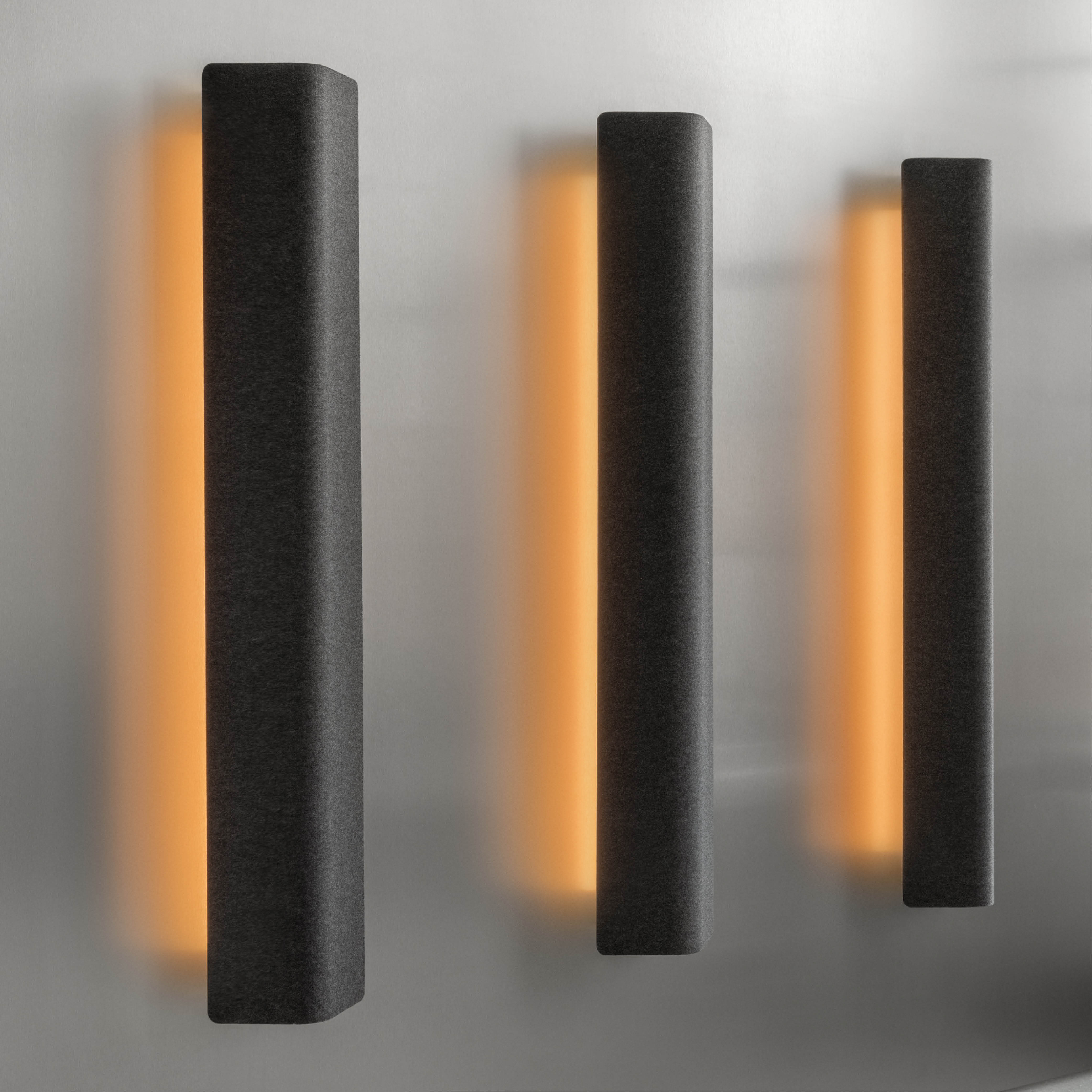 three dark grey acoustic sconces with lights